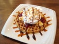 Banana split with whip cream, ice cream, strawberry jam and syrup on top of waffle Royalty Free Stock Photo