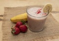 Banana Strawberry Milkshake. Glass cup on a wooden background. Homemade Royalty Free Stock Photo