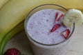 Banana Strawberry Milkshake. Glass cup on a wooden background. Homemade Royalty Free Stock Photo