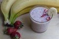 Banana Strawberry Milkshake. Glass cup on a wooden background. Homemade Royalty Free Stock Photo