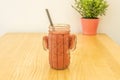 A banana and strawberry smoothie in a glass bowl on a pine wood table Royalty Free Stock Photo