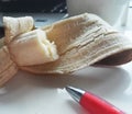 Banana on table with computer and red pen Royalty Free Stock Photo