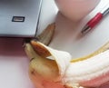 Banana on table with computer and red pen Royalty Free Stock Photo