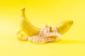 Banana with tape for measuring figure. Centimeter ruler spinned around fruit. Tape wrapped around banana isolated on yellow Royalty Free Stock Photo