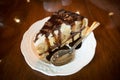 Banana Vanilla Cake with Chocolate in a white dish placed on a wooden background in a cafe.Selective focus Royalty Free Stock Photo