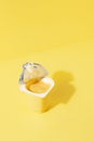 Banana and vanilla pudding or yogurt plastic cup on pastel yellow background