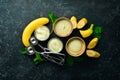 Banana yellow ice cream with mint and fresh banana. Ice cream spoon. On a black stone background
