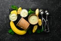 Banana yellow ice cream with mint and fresh banana. Ice cream spoon. On a black stone background,