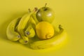 Bananas apple and lemon on yellow background Royalty Free Stock Photo