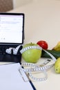 Bananas, apple, vegetable, laptop, tape-measure, tablet, on dietitian\'s table to calculate ration Royalty Free Stock Photo