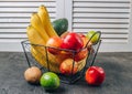 Bananas, apples, kiwi, lime and avocado in black metal basket. Ecological Zero Waste Food Shopping concept.