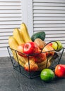 Bananas, apples, kiwi, lime and avocado in black metal basket. Ecological Zero Waste Food Shopping concept.