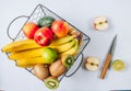 Bananas, apples, kiwi, lime and avocado in black metal basket. Ecological Zero Waste Food Shopping concept.