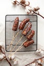 Bananas in chocolate with a multicolored powder lying on a black baking tray