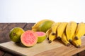 Bananas and guavas on polished wood, placed on rustic wood with selective focus