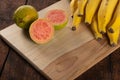 Bananas and guavas on polished wood, placed on rustic wood with selective focus