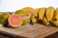 Bananas and guavas on polished wood, placed on rustic wood with selective focus