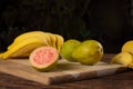 Bananas and guavas on polished wood, placed on rustic wood with selective focus