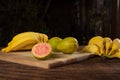 Bananas and guavas on polished wood, placed on rustic wood with selective focus