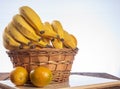 Bananas and oranges in a basket placed in polished wood on rustic wood with selective focus Royalty Free Stock Photo