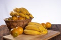 Bananas and oranges in a basket placed in polished wood on rustic wood with selective focus Royalty Free Stock Photo