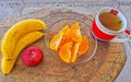 Bananas sliced oranges and red apple fruit and ginger tea