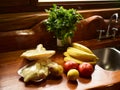 In a kitchen of a cabin several fruits, vegetables and meat are observed