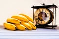 Bananas and vintage clock on a warm summer day