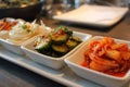 Banchan platter featuring kimchi, pickled daikon, and fresh vegetables on a dining table Royalty Free Stock Photo