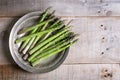 Banches of fresh green asparagus in a metallic jar on wooden background Royalty Free Stock Photo