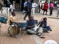 Band of blind beggar playing music in pavement