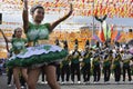 Band majorettes perform flag waving dancing skills on street during the annual brass band exhibition