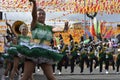 Band majorettes perform flag waving dancing skills on street during the annual brass band exhibition