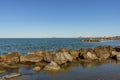 A band of natural rocks forming a natural breakwater protecting the sea beach