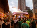 Band plays on stage as crowd watches at St. Patrick's Day Block Party in street