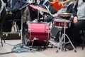 A band preparing to perform in the street at summer open-air. Maroon drum set, red guitar, mic, other musical equipment. Royalty Free Stock Photo