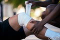 Bandage on legs, injury and pain, sports emergency or accident outdoor with knee sprain, first aid for medical and