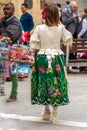 A women in a traditional embroidered skirt walking in the street during the spring festival of Bando de la Huerta in Murcia, Spai