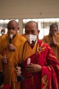 The chief monks and the monks use a mic while talking and praying to the congregation