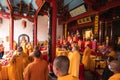 Bandung, Indonesia - January 8, 2022 : A Group of monks with orange and red robes praying together at the altar