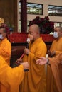 Bandung, Indonesia - January 8, 2022 : A Group of monks with orange and red robes praying together at the altar