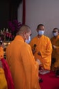 Bandung, Indonesia - January 8, 2022 : A Group of monks with orange and red robes praying together at the altar