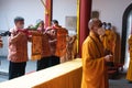 Bandung, Indonesia - January 8, 2022 : The monks in orange rob standing in order while praying to the god at the altar inside the