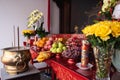 Bandung, Indonesia - January 8, 2022 : The offerings like food and candle on the top of the red Buddhist table during the praying