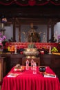 Bandung, Indonesia - January 8, 2022 : The offerings like food and candle on the top of the red Buddhist table during the praying