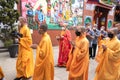 The servant and the monks walking line up in the flock to the Buddhist temple