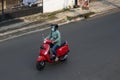 A woman riding a red Vespa. Royalty Free Stock Photo