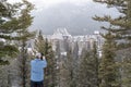 Banff, Alberta Canada - Male tourist photographs a winter scene view of the famous Fairmont Banff Springs Hotel, as