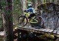 A young boy rides his mountain bike down a wooden ramp on the Top Notch cycling trail on Tunnel