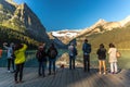 Banff, Canada - Ago 14th 2017 - Group of tourists in front of Lake Moraine in the early morning. Blue sky, mountains in the backgr Royalty Free Stock Photo